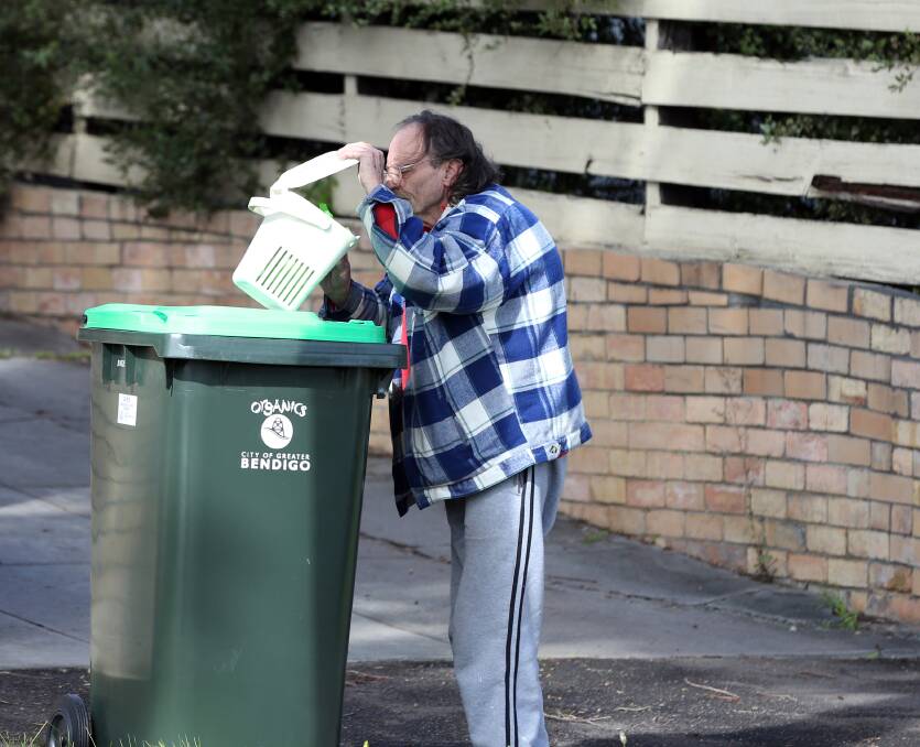 NEW ARRIVAL: A resident checks out his new green bin, kitchen caddy and bins liners. Picture: GLENN DANIELS