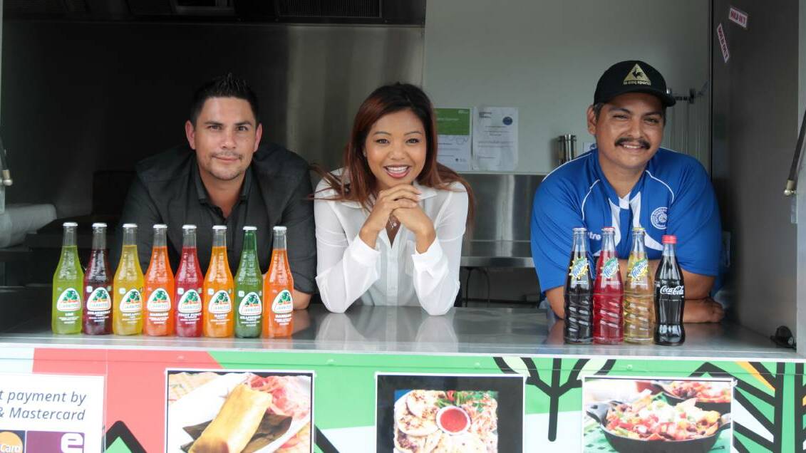 Market watch: Organisers Sam Adams and Phaly My with one of the food vendors Marvin Antonio Barahona who sells Salvadorian food. Picture: Simon Bennett