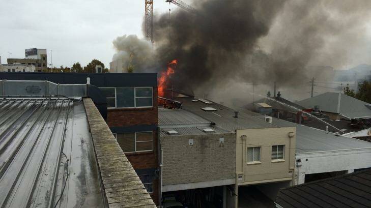 Flames break through the roof of a building on Alexander Street in Crows Nest. Photo: Grant Potter