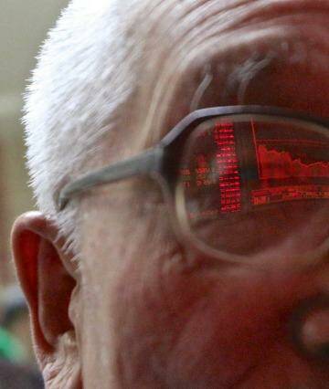 An 82-year-old retiree is a regular at the China Securities office in Beijing where he monitors the rise and fall of one of the two shares he holds. Photo: 5iphoto
