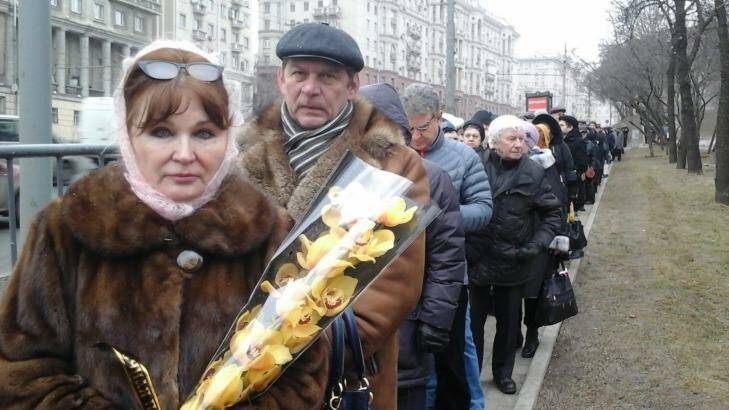 A Russian woman holds orchids at the front of a line for the funeral of Boris Nemtsov. Photo: Helen Womack