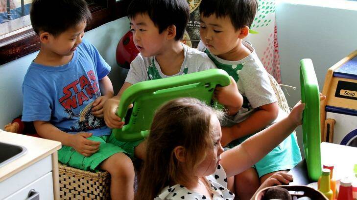 Children at the Top Ryde Early Learning centre using a new language app on a tablet. Photo: Ben Rushton
