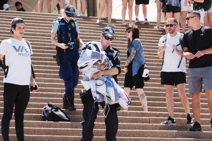 At 10:30 am activists tried to unfurl a protest banner over the west-facing sail of the Sydney Opera House with personal banners calling to #EvacuateManus. Pictured are the two protestors arrested. Thursday 9th November 2017. Photograph by James Brickwood. SMH NEWS 171109