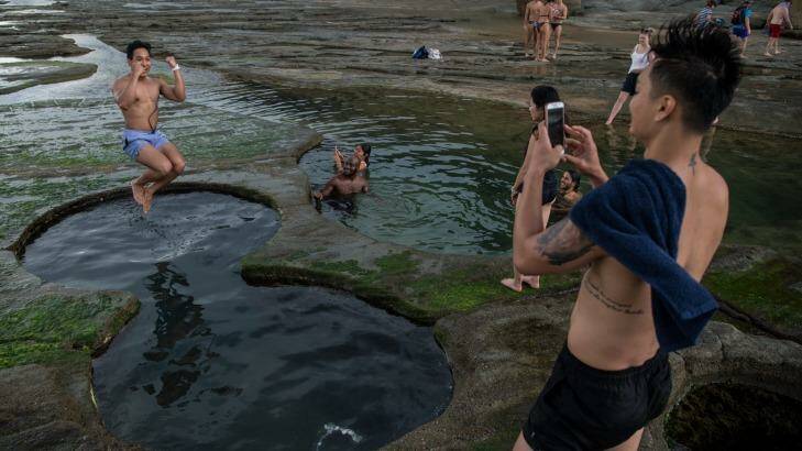 Tourists pose for photographs earlier in January at the Figure Eight Pools in the Royal National Park. Photo: Wolter Peeters
