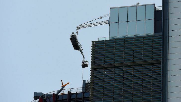 A damaged crane hangs from the 51st floor of the highest tower at Barangaroo in the Sydney CBD. Photo: Kate Geraghty