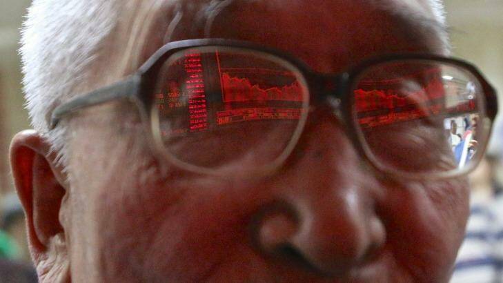 An 82-year-old retiree is a regular at the China Securities office in Beijing where he monitors the rise and fall of one of the two shares he holds. Photo: 5iphoto