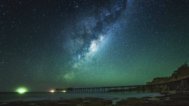 Hundreds of galaxies have been discovered hiding behind the glowing disk of the Milky Way. This photo was taken at Catherine Hill Bay. Photo: Karl Lindsay
