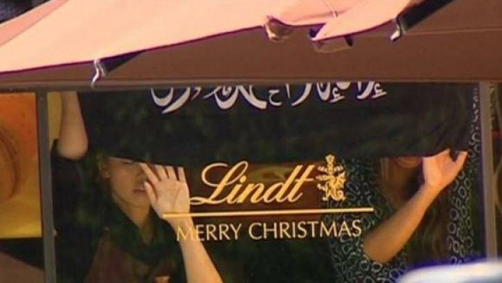 Hostages were seen holding an Islamic flag that is not the Islamic State flag against the window of the Lindt Chocolat Cafe in Martin Place.