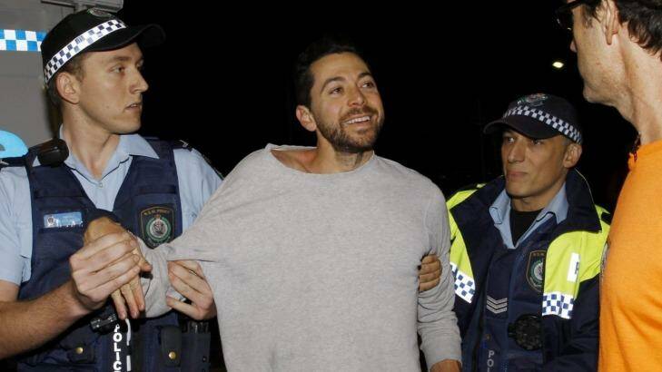 James Mathison is led away by police after trying to scale one of the Moreton Bay Fig trees on Anzac Parade, Moore Park, at a protest before they are cut down tonight in Sydney. Photo: Janie Barrett