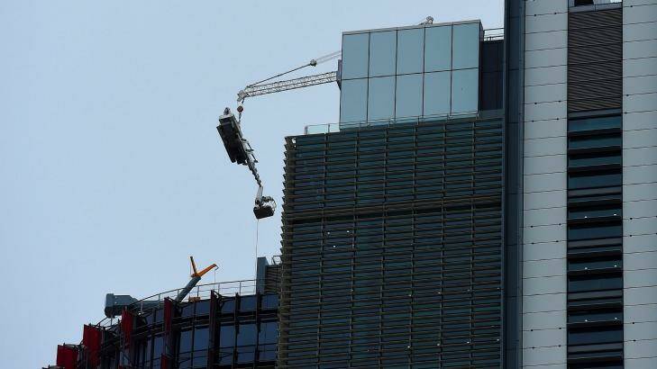 The damaged crane hangs from the 51st floor of the highest tower at Barangaroo in the Sydney CBD. Photo: Kate Geraghty