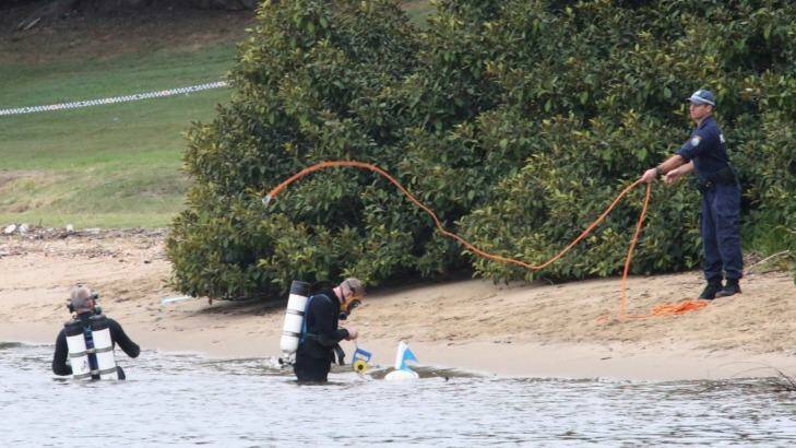 Police divers search the water around Cabarita Wharf, where the body of a woman was found. Photo: Peter Rae